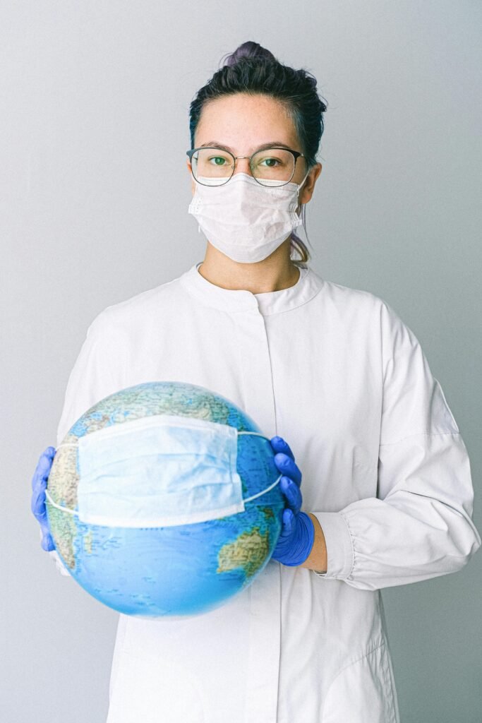 Photo Of Person Wearing Protective Wear While Holding Globe